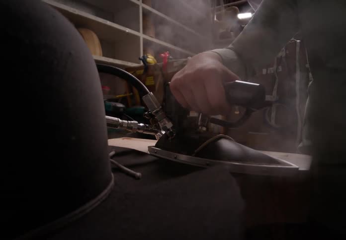 A person is ironing a cowboy hat in the shop