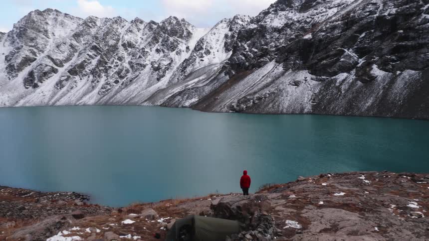 A person looking at a lake in the mountains