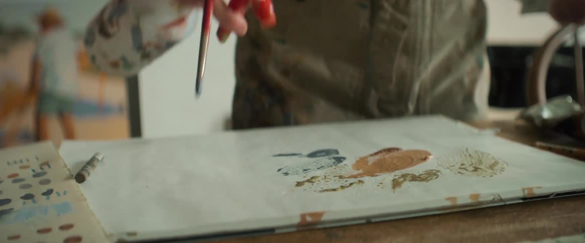 A painter cleaning his brushes on a white canvas