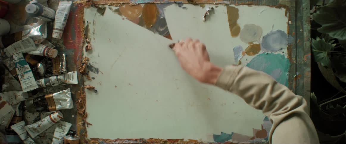 A person removing paint from a painting