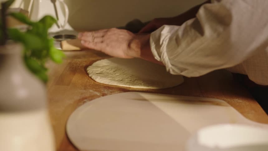 A man rolling dough on a table