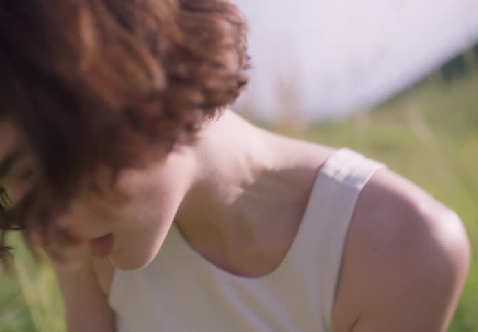 Woman dancing scenically on an open lawn in a natural environment in the daylight