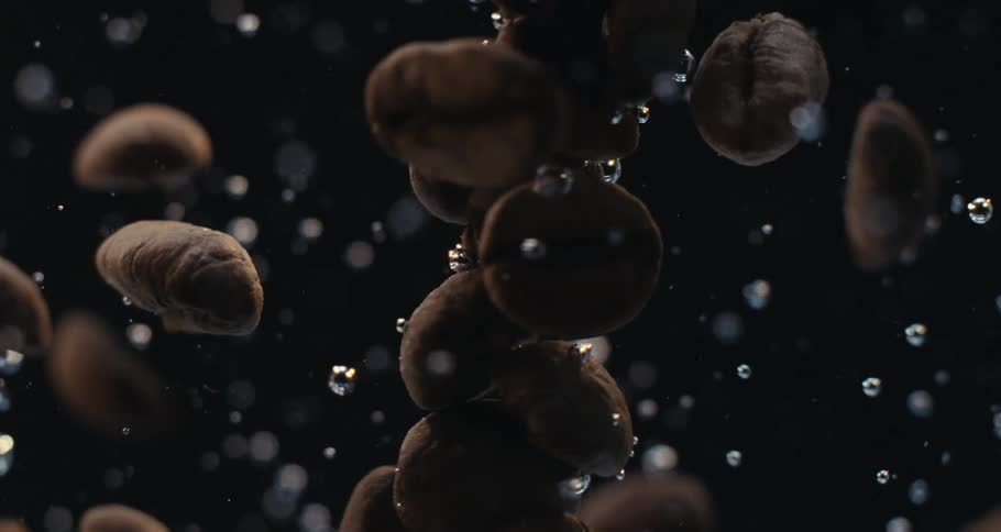 Extreme closeup of coffee beans in a spiral pattern with water bubbles