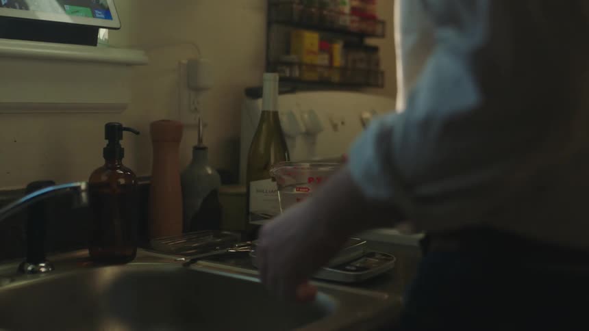 A person is wanting some water from a container and puts it on the stove to boil the water