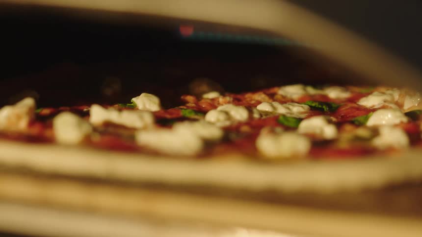 Pizza being baked with bubbling tomato sauce