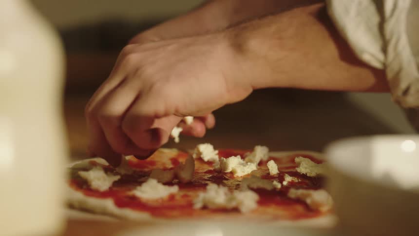 A person preparing a pizza