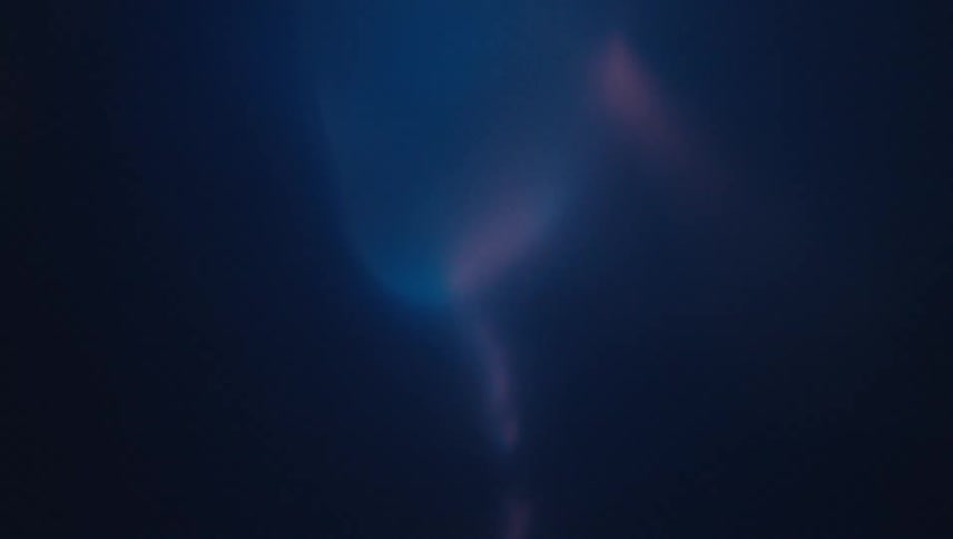 Flames of fire rotating rapidly beneath a blue liquid