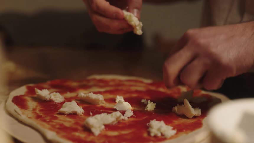 A person is making a pizza at home