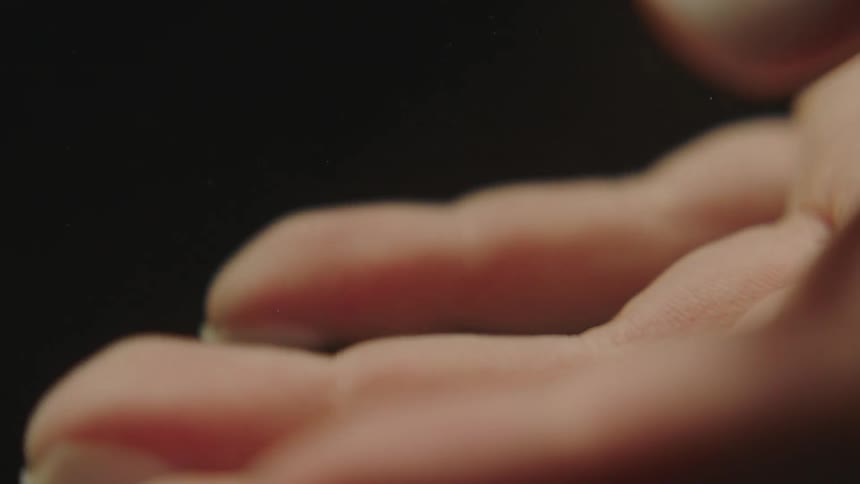 A woman slowly extends and bends the fingers on her right hand