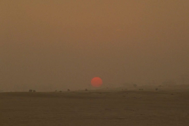 Panoramic view of the desert with a red moon on the horizon