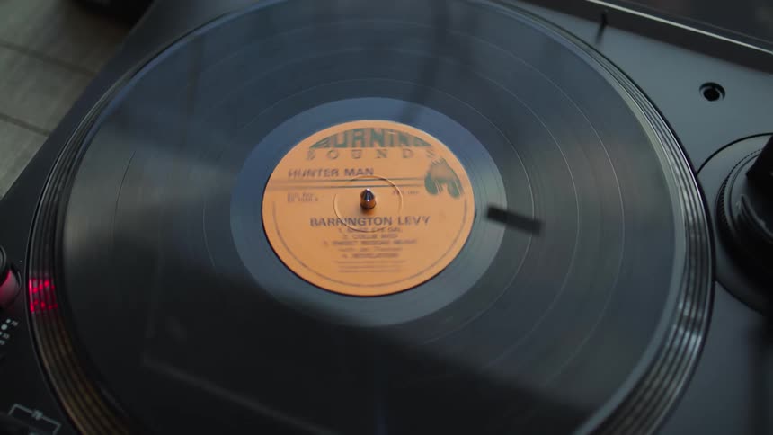 A vinyl record album spins on a turntable as it plays