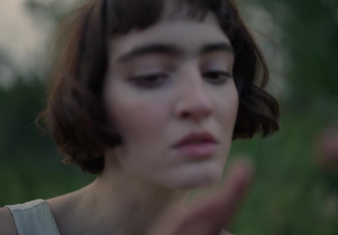 A young woman in the forest showing gesture with her hands