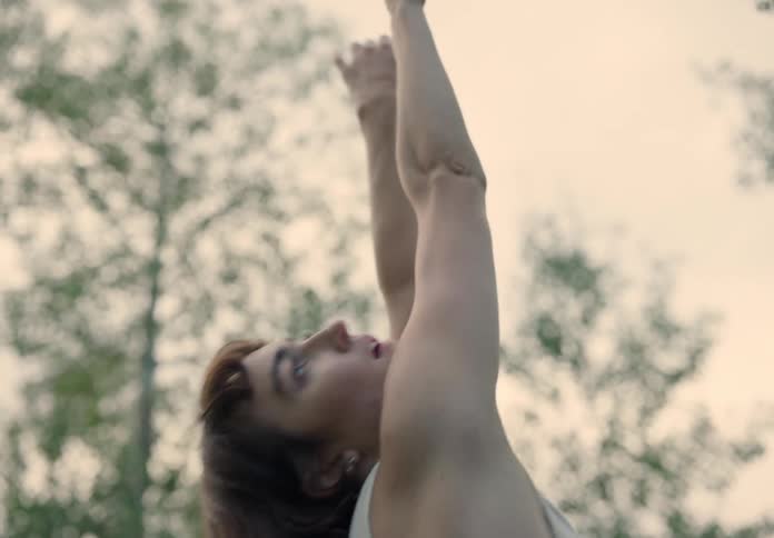 Woman dancing gracefully in nature on a cloudy day