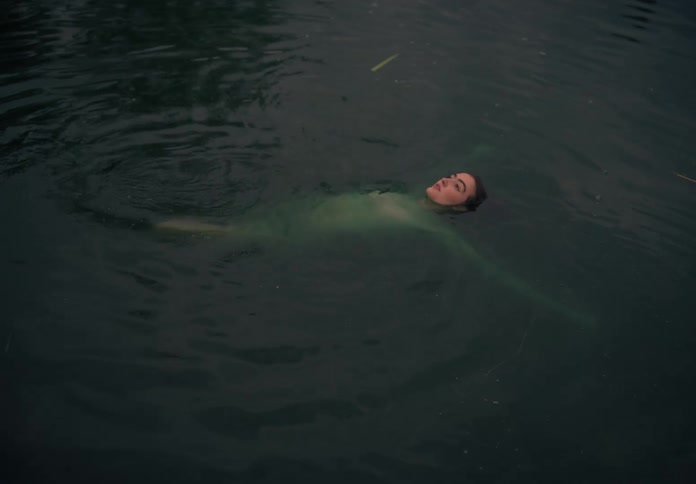 A woman is on the surface of the water face up