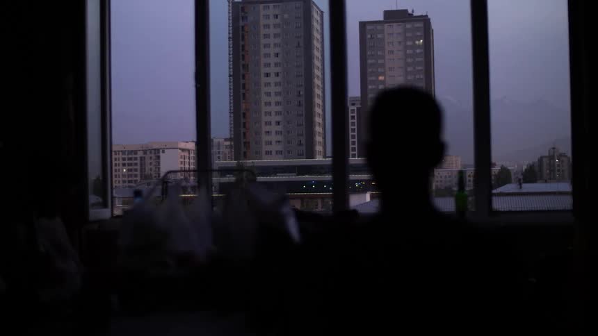 Silhouette of a person looking at buildings in the city