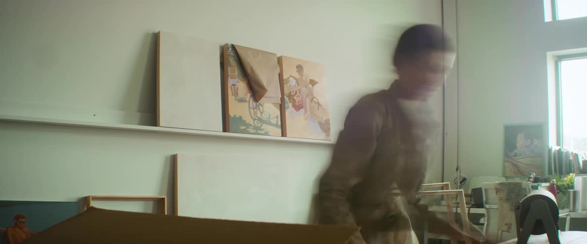 A woman packing paintings in cardboard boxes