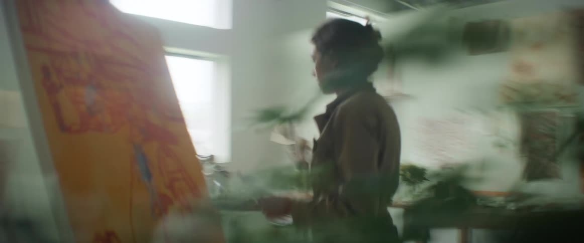 Woman painting with a canvas inside a room