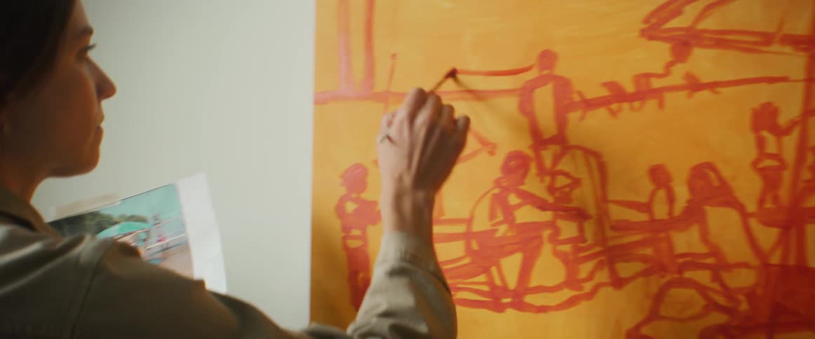 Artist standing in front of a canvas painting
