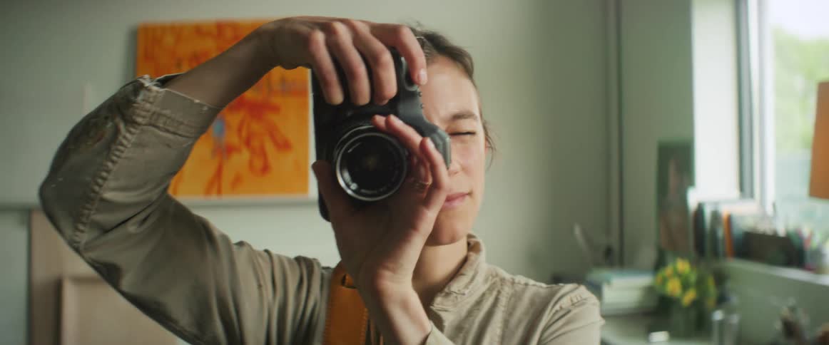 Portrait of a young woman taking a photo with a professional camera
