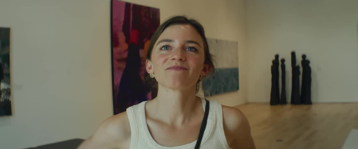 Lady smiling while standing inside an art gallery