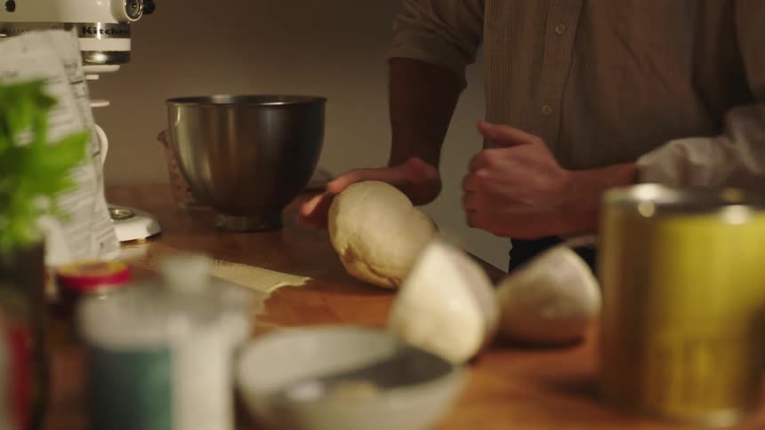 A person preparing dough at the kitchen table