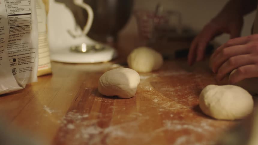 A hand of a person is preparing a dough