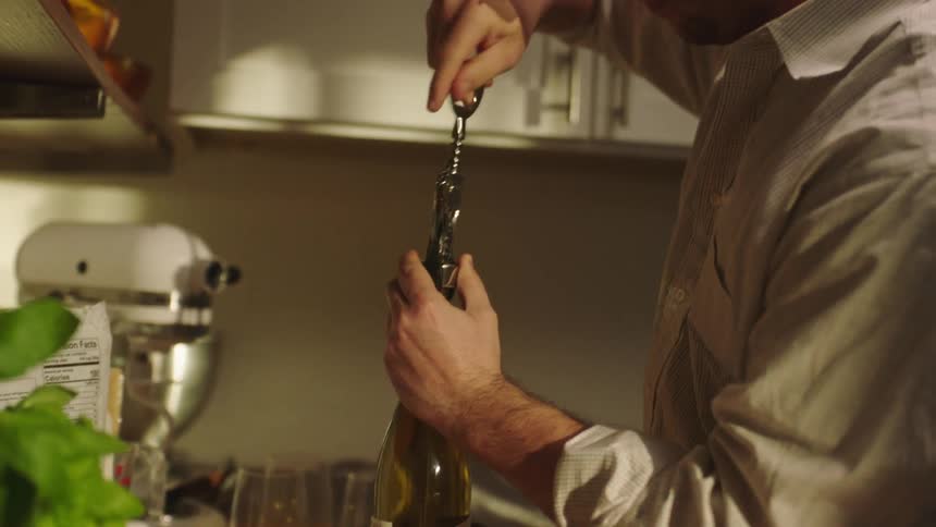 Portrait of a man opening a bottle of wine