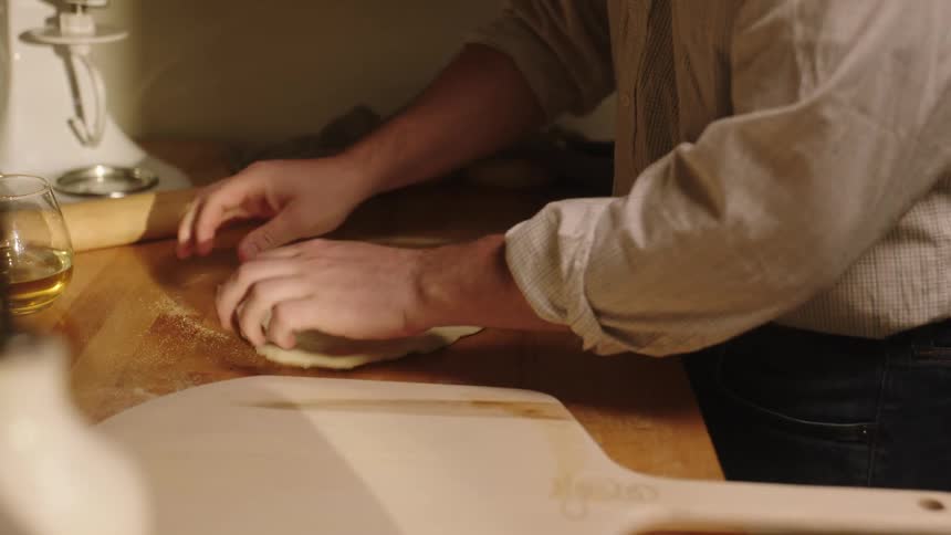 A person preparing pizza dough