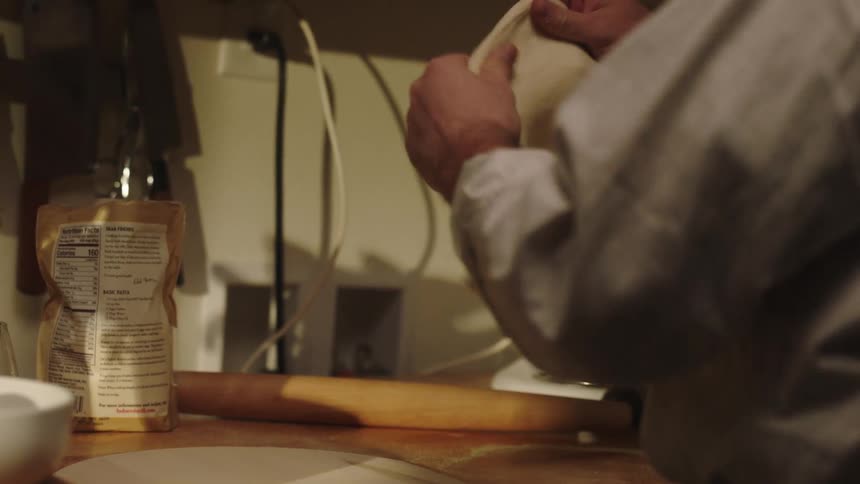 A person is rolling out and kneading bread dough