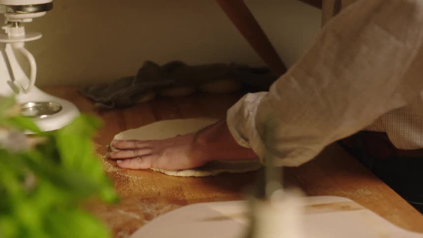 Man in the kitchen kneading dough