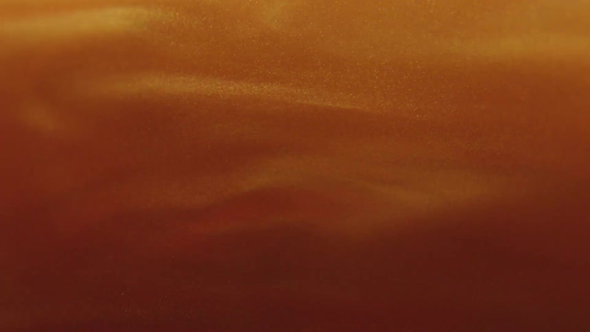 Extreme closeup of golden powder in slow motion