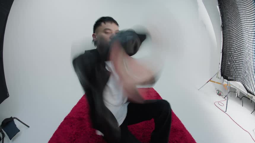 Man dancing on a red carpet in a white studio room