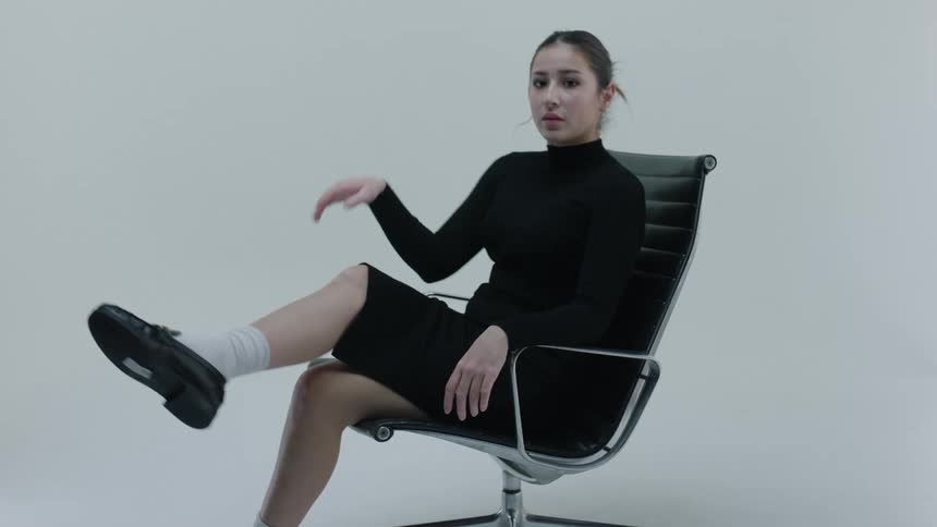 Woman sitting in chair spins forward and poses