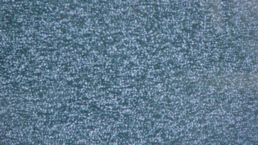 Extreme closeup of a screen with no signal displaying flickering white and black dots