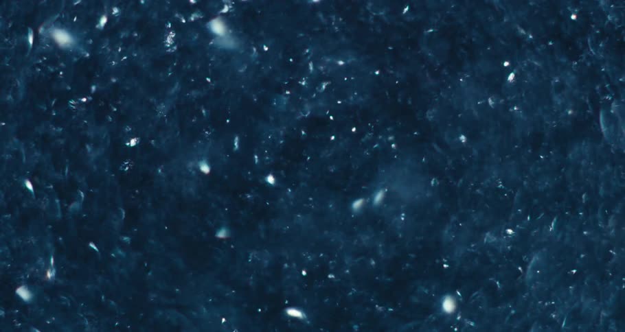 Extreme closeup of water with glimmering reflections in slow motion