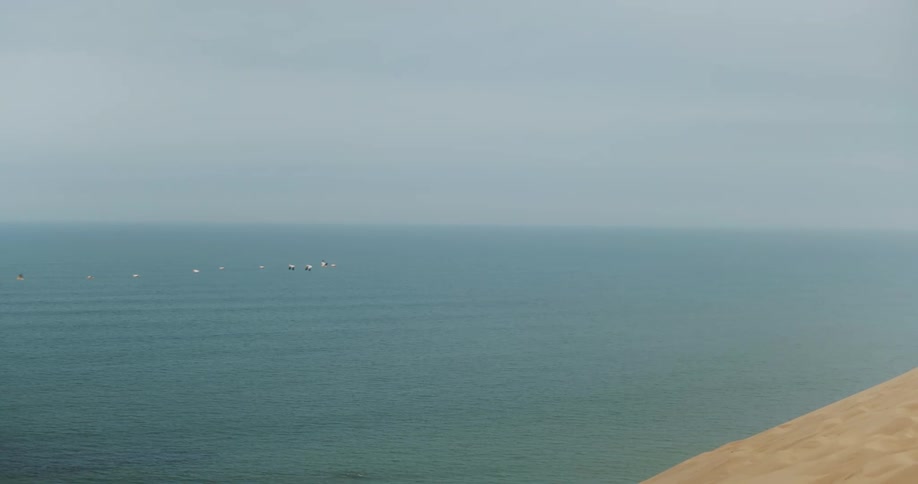 View of the blue sea with birds flying
