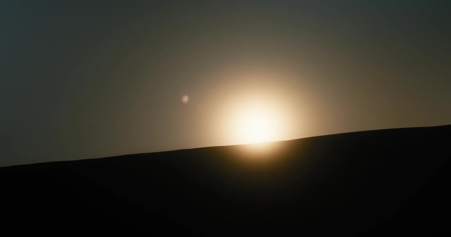 Sun sets over the sand dunes in the desert