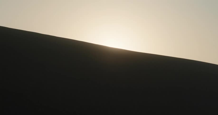 Sun rises over a dune in the desert