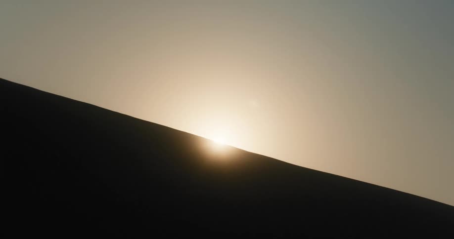 Upward view of the sky with the sun on a silhouette wall