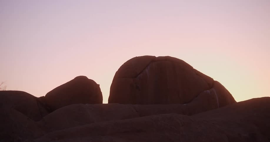 Morning sunlight behind large boulders in the mountains