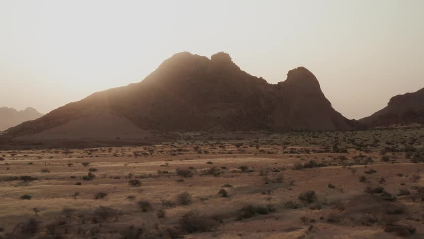 Sun shines over the ridge of a mountain in the desert