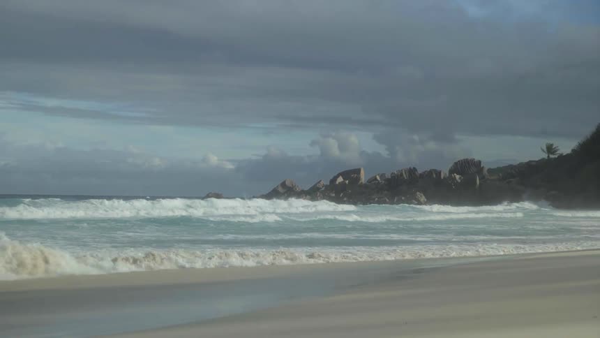 A beach with several small waves breaking on the shore