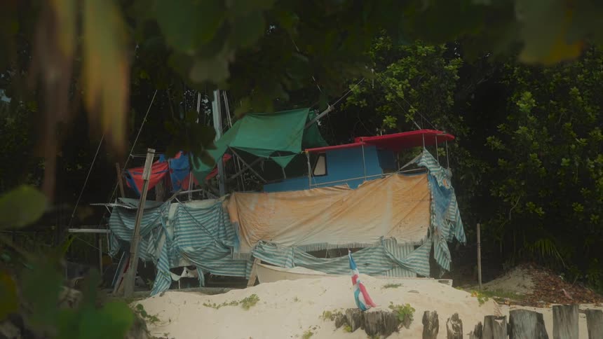 Shelter made with cloths amidst a corner in the trees