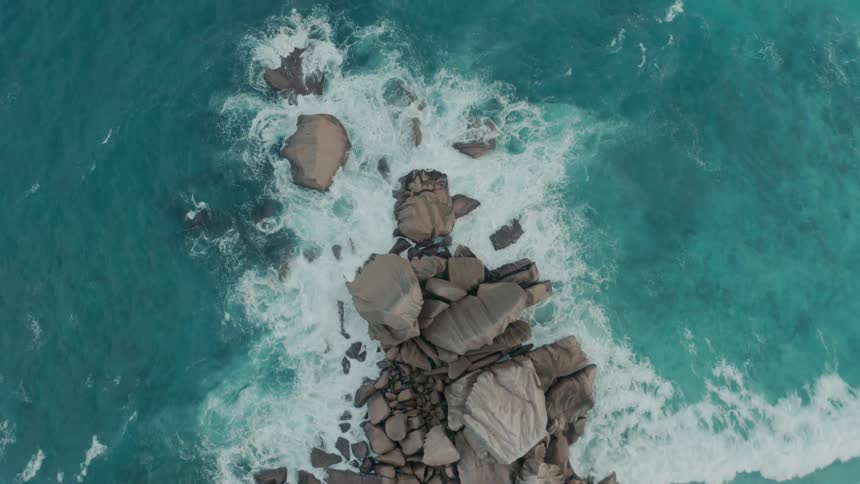 Several sea waves breaking in an area with some rocks