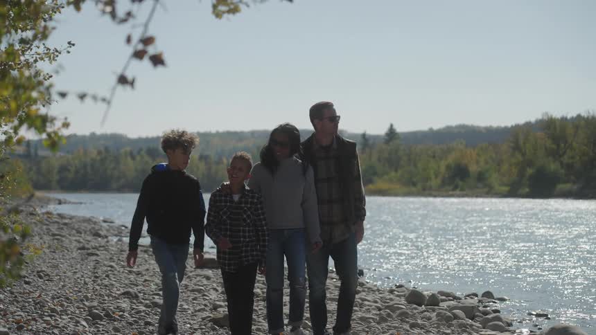 A group of people walking beside a river