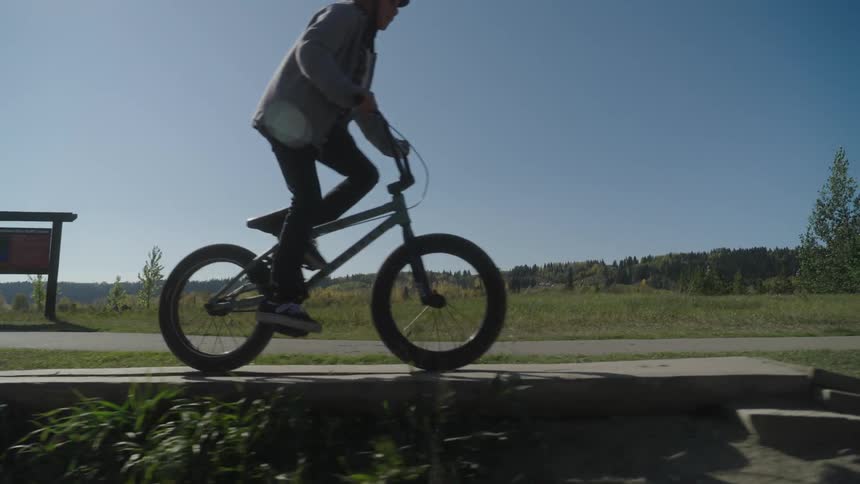 Boy riding a bicycle and going over a small ramp