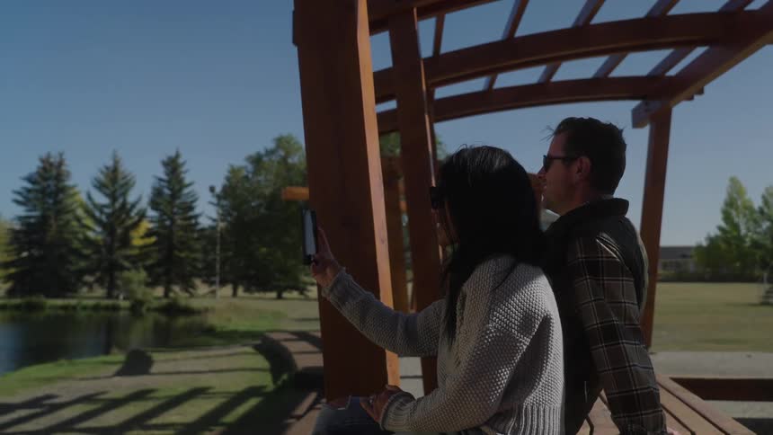 A woman is using her phone in the park