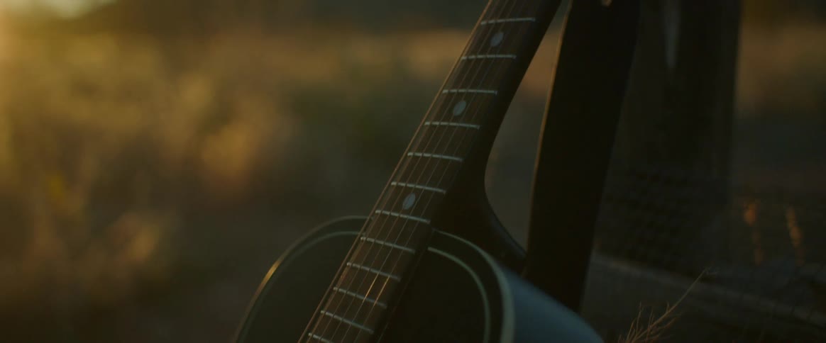 A guitar is leaning against a post on the field