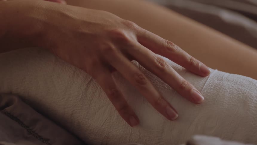 Woman rubbing her leg that is cast and bandaged