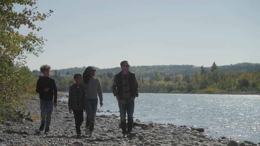Family walking on the coastline along a river